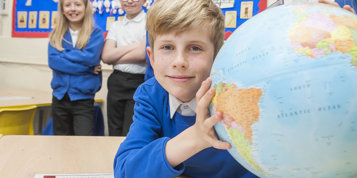 A boy holding a globe